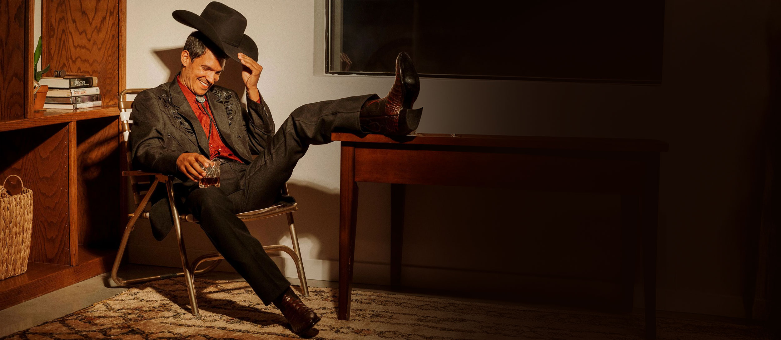 A man sitting on an office chair wearing Signature Series Boots.